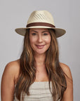 A woman  wearing a white tube and a panama sun hat