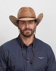 A smiling man in a navy blue polo wearing the Toast Cowboy Hat