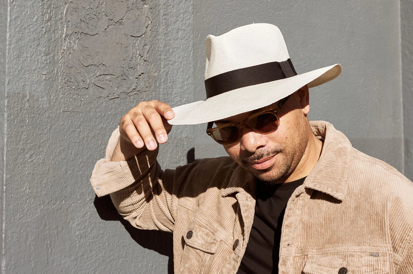 Man standing against wall wearing the Afternoon sun hat by American Hat Makers