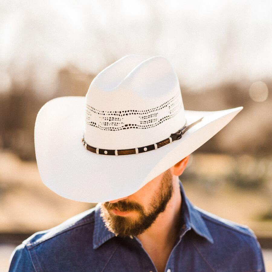 A man in blue polo wearing white hat