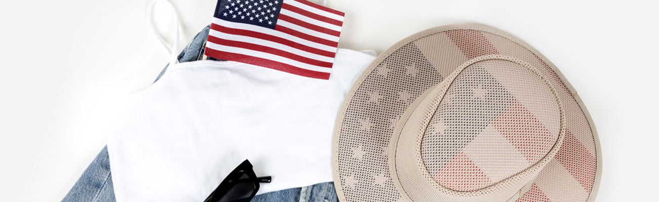 A white tank top, denim jeans, flag and a tan mesh hat