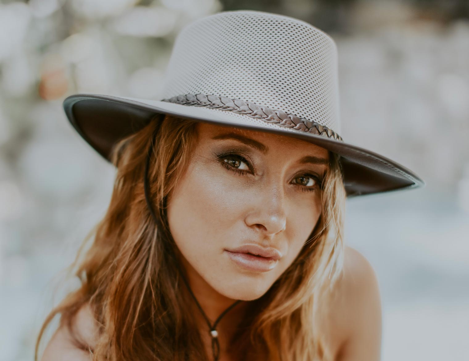 woman wearing a eggshell colored soaker sun hat from american hat makers