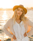 A woman on a boat wearing copper leather hat
