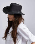 A woman with long hair wearing black hat