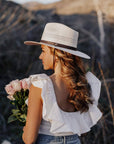 A woman wearing Cream Straw Sun Hat on a back view