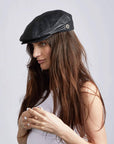 A woman wearing Bookie Leather Black Flat Cap on a side view