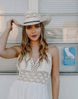 A woman in white dress wearing Bozeman Cream Straw Cowboy Hat