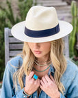 A woman in a garden wearing a denim jacket and a Panama Fedora Hat in a right view