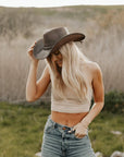 A woman standing outdoors wearing Brown Leather Cowboy Hat