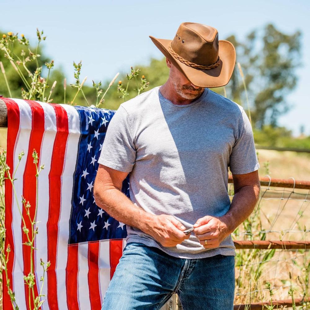 Man standing next to American Flag while wearing the Hollywood Copper Leather Cowboy Hat by American Hat Makers