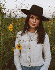 A woman standing around the plants wearing Hudson Black Felt Fedora Hat
