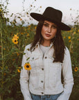 A woman standing around the plants wearing Hudson Black Felt Fedora Hat 