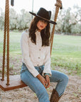A woman on a swing wearing white tops and a Hudson Black Felt Fedora Hat