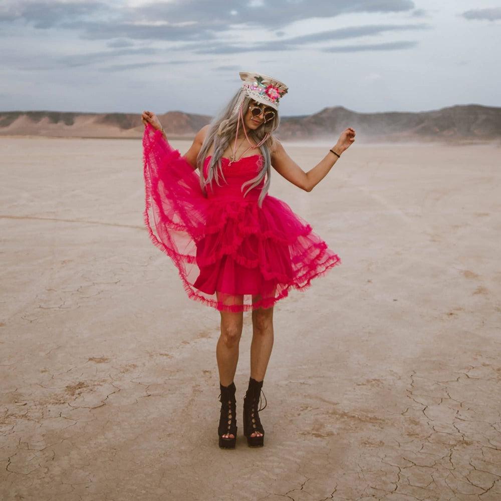 a woman in pink dress wearing a Lola Silver Burning Man Hat on a desert