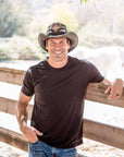 A man leaning in the fence wearing Black Finished Storm Cowboy Hat Double Rattle Band 