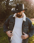 A man in denim jacket wearing a Black Leather Cowboy Hat 