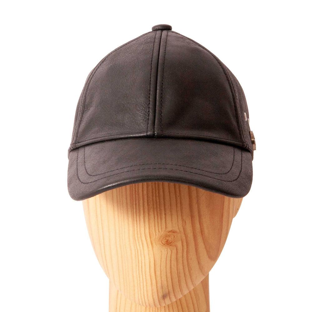 A front view of a Sidecar Black Leather Cap for Men  placed on a wooden stand