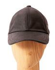 A front view of a Sidecar Black Leather Cap for Men placed on a wooden stand