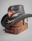A Black Finished Storm Cowboy Hat with Double Rattle Band on a stand