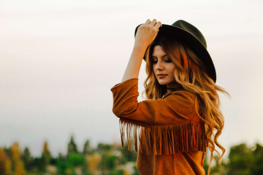 https://americanhatmakers.com/cdn/shop/articles/woman-colored-hair-with-cowboy-hat-in-field_1024x1024.jpg?v=1659996158