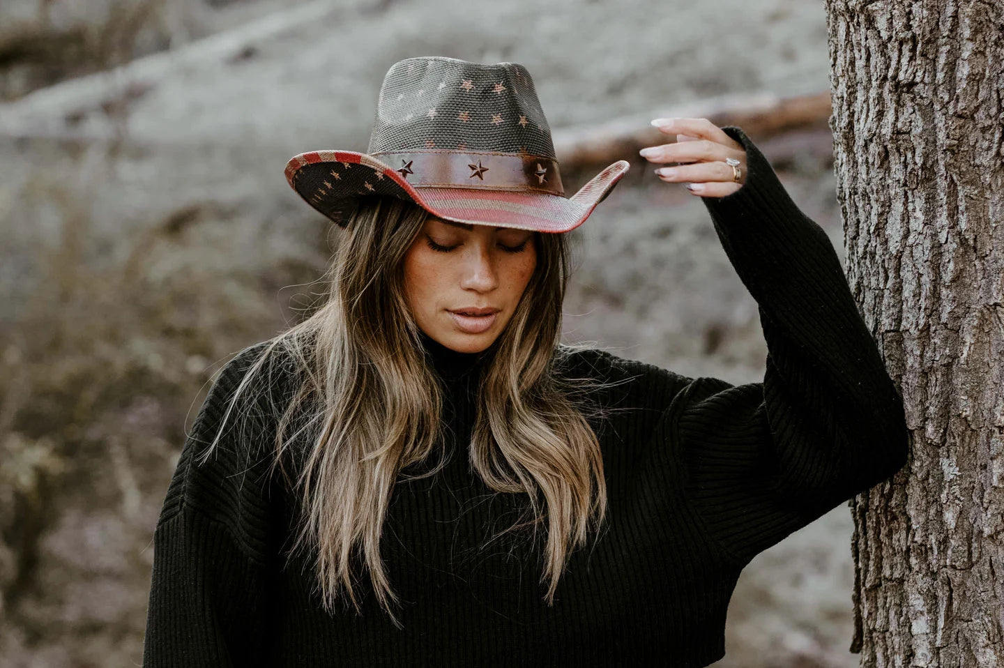 cowgirl leaning against tree wearing the Americana womens cowgirl hat by American Hat Makers