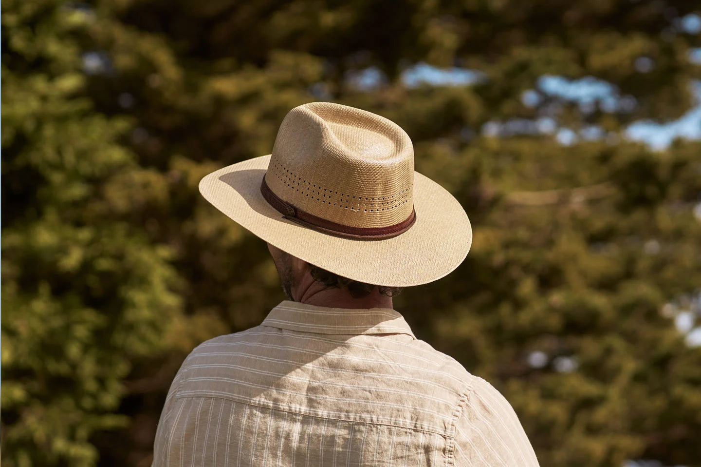 Man next to trees while wearing the Barcelona mens sun hat by American Hat Makers