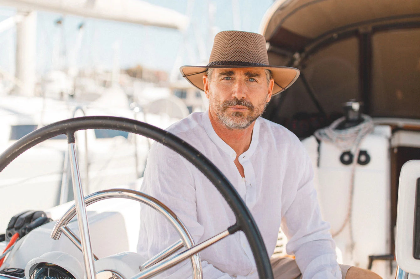 Man on boat wearing the Breeze mens sun hat by American Hat Makers