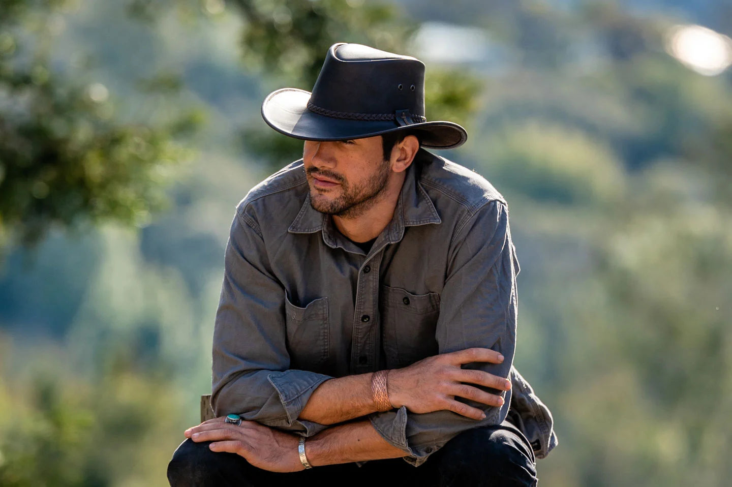 Man sitting in nature while wearing the bushman brown mens leather hat