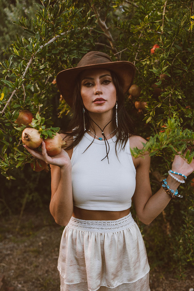 A woman picking fruits wearing copper leather hat