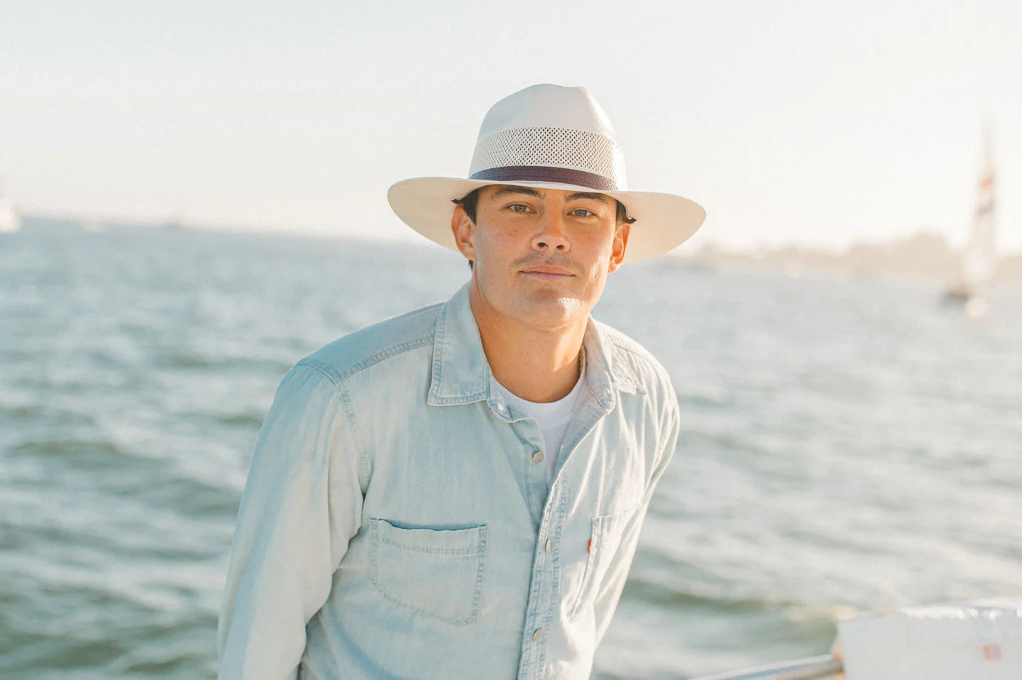 men wearing blue denim sailing in an ocean wearing a sun festival hat by american hat makers