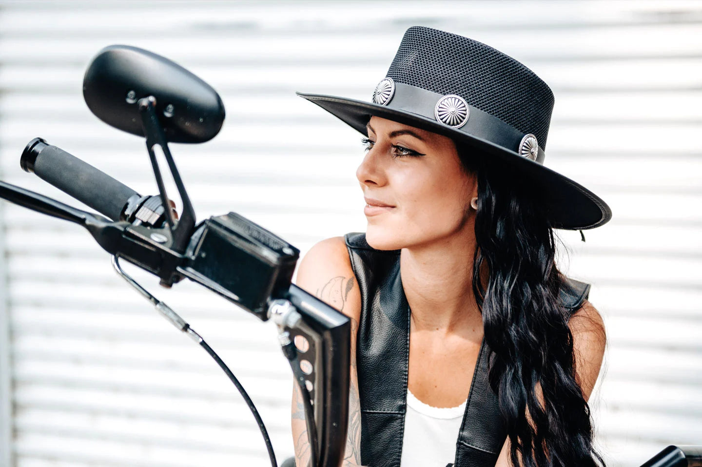 Woman sitting on motorcycle wearing the Gaucho womens pork pie hat by American Hat Makers