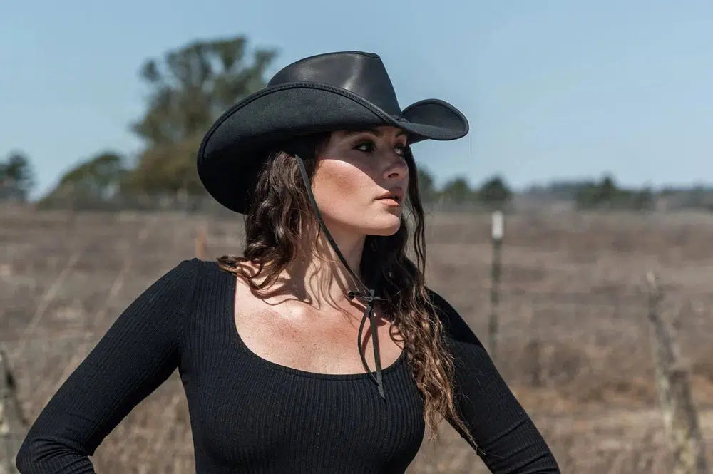 Hollywood Womens Black Leather Cowboy Hat on a woman standing in a field wearing a black top