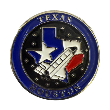 A circular Texas Houston emblem pin featuring a blue outer ring with silver lettering, a black center, the state of Texas with a white star, a white rocket, and a red section.