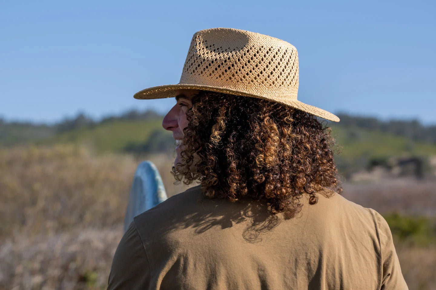 man in a field wearing a jude straw sun hat for men by american hat makers
