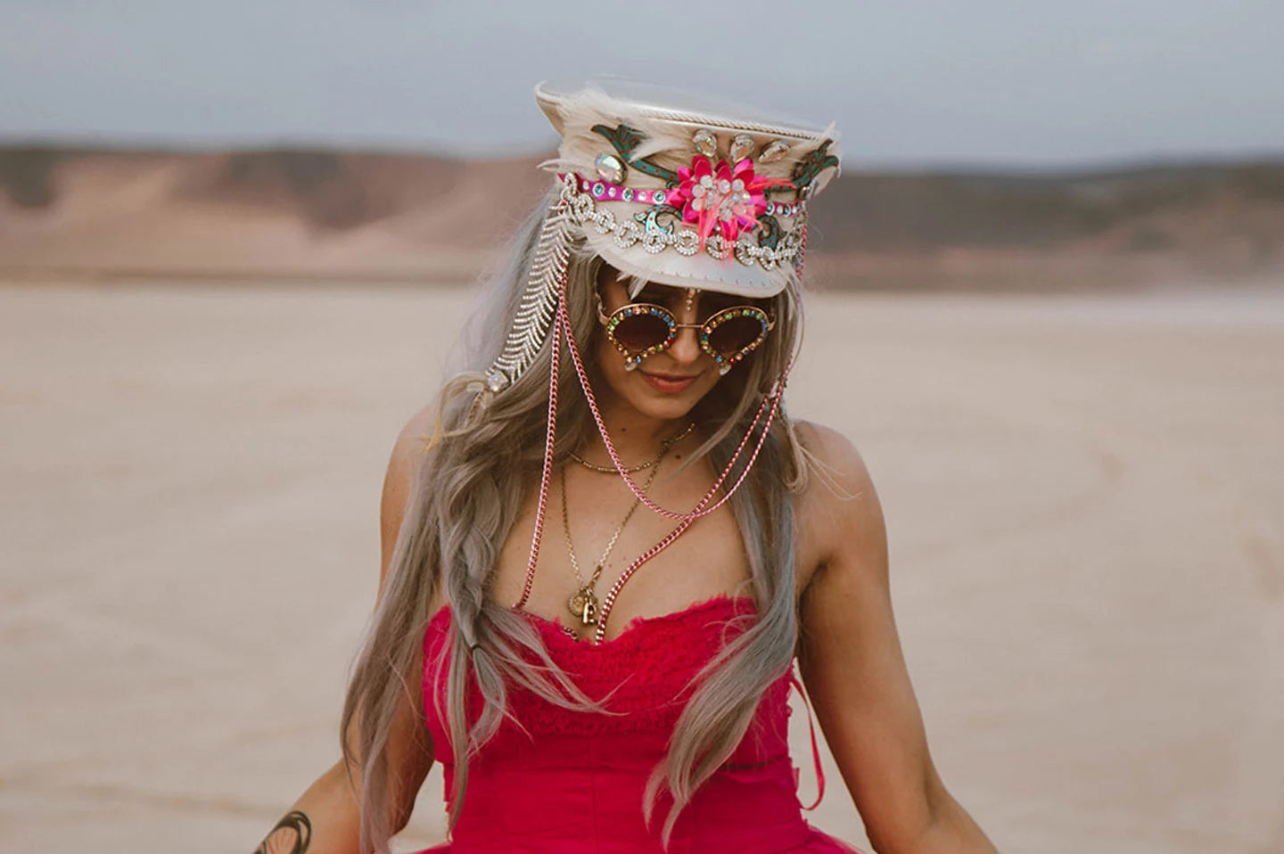woman in a red dress in a desert wearing a festival hat by american hat makers
