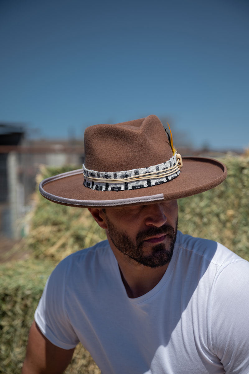 A man wearing a brown felt fedora hat