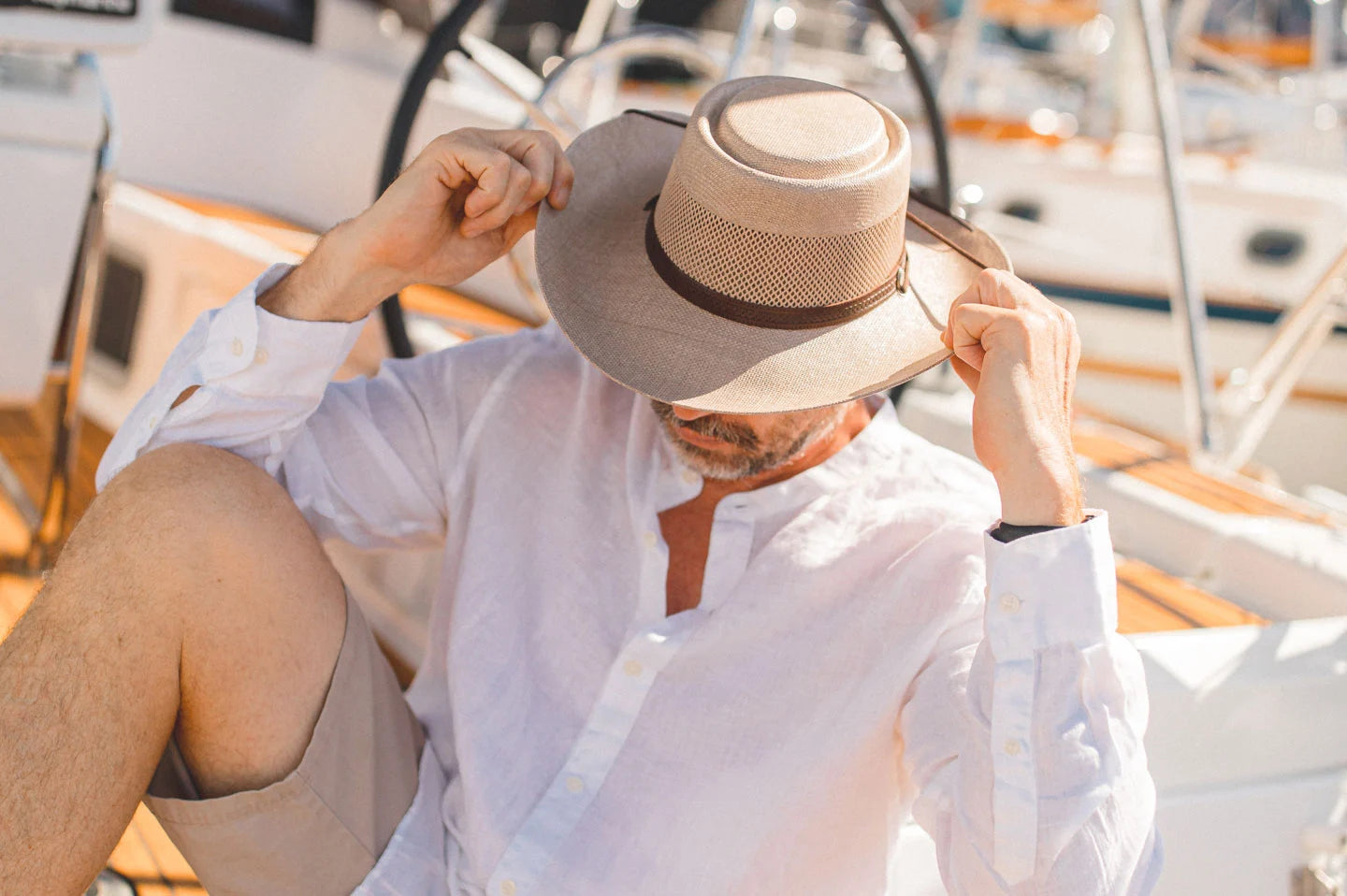 Man sitting on boat wearing the Madrid mens hat by American Hat Makers