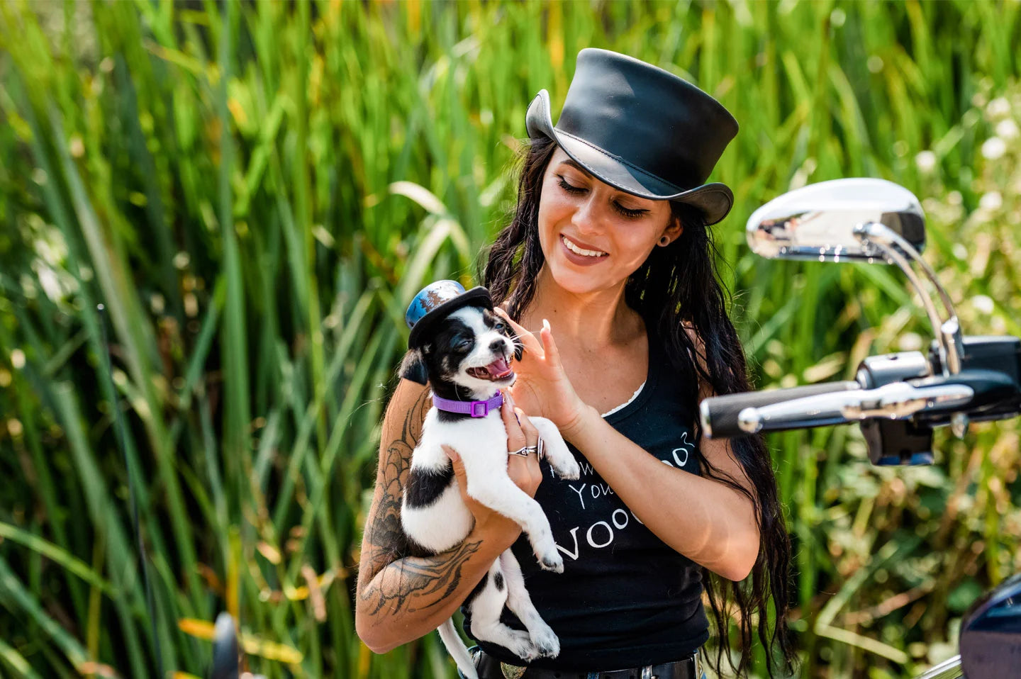Woman holding dog next to motorcycle wearing the unbanded Marlow womens top hat by American Hat Makers