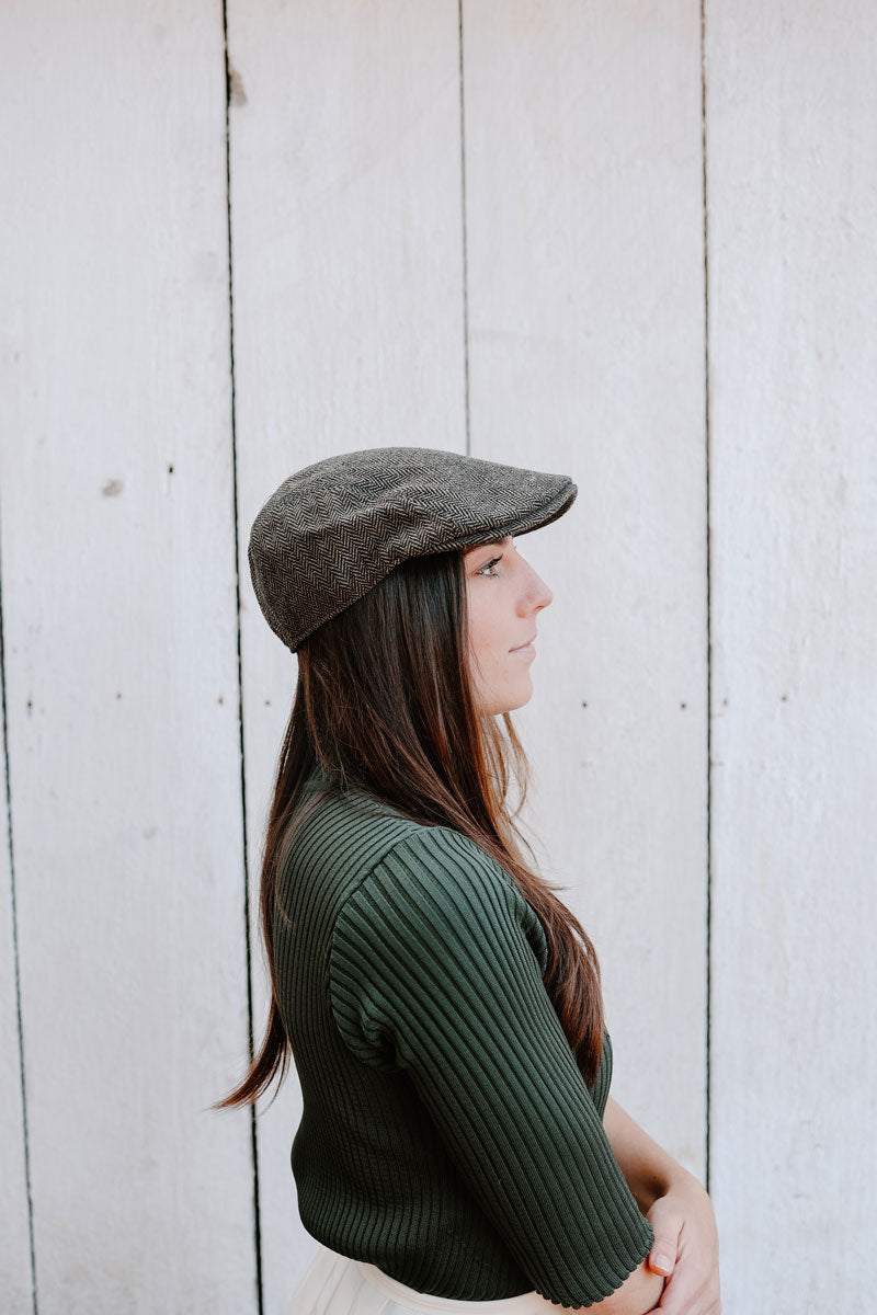 A woman facing side view wearing a mikey brown cap