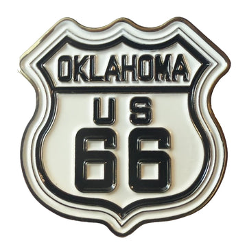 An enamel shield-shaped pin featuring the 'Oklahoma US 66' Route 66 design, with black lettering and border on a white enamel background.