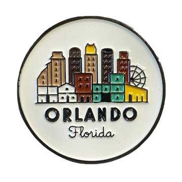 A round white enamel pin featuring a colorful stylized skyline of Orlando, Florida, with the text 'ORLANDO Florida' below the buildings.