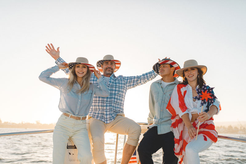 A group wearing a patriotic ivory sun hats while on a boat