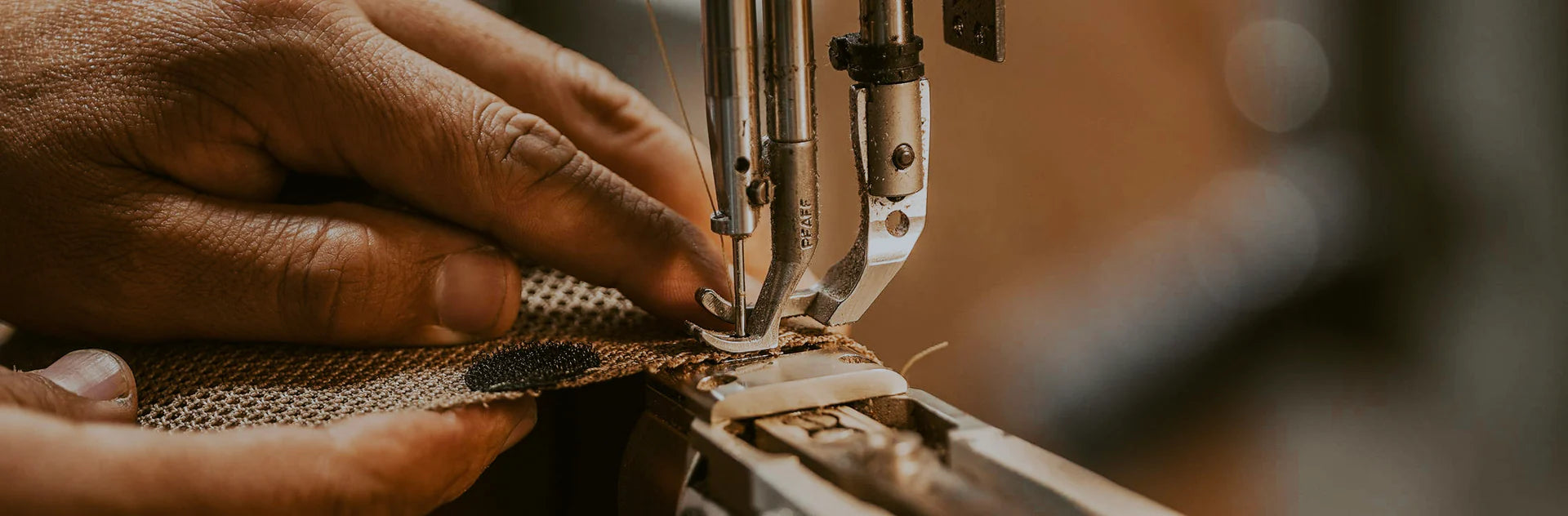 A hand sewing on a sewing machine