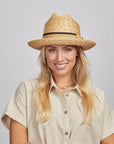 Woman with blonde hair wearing a Sawyer Straw Hat and a beige shirt.