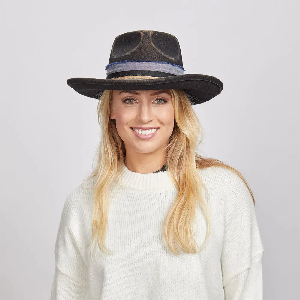 Woman smiling and wearing a Small Town felt fedora hat and white sweater.
