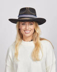 Woman smiling and wearing a Small Town felt fedora hat and white sweater.