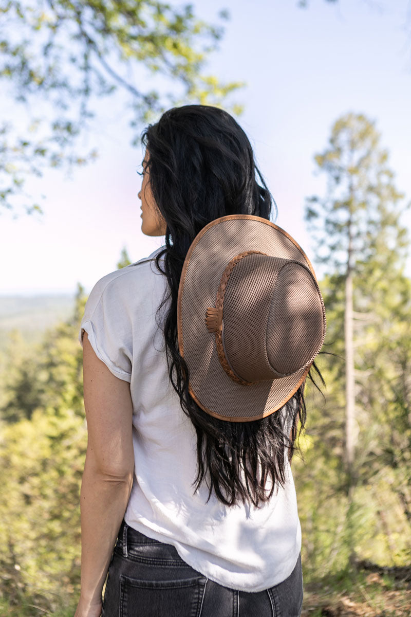 A woman on an adventure wearing a tan sun hat