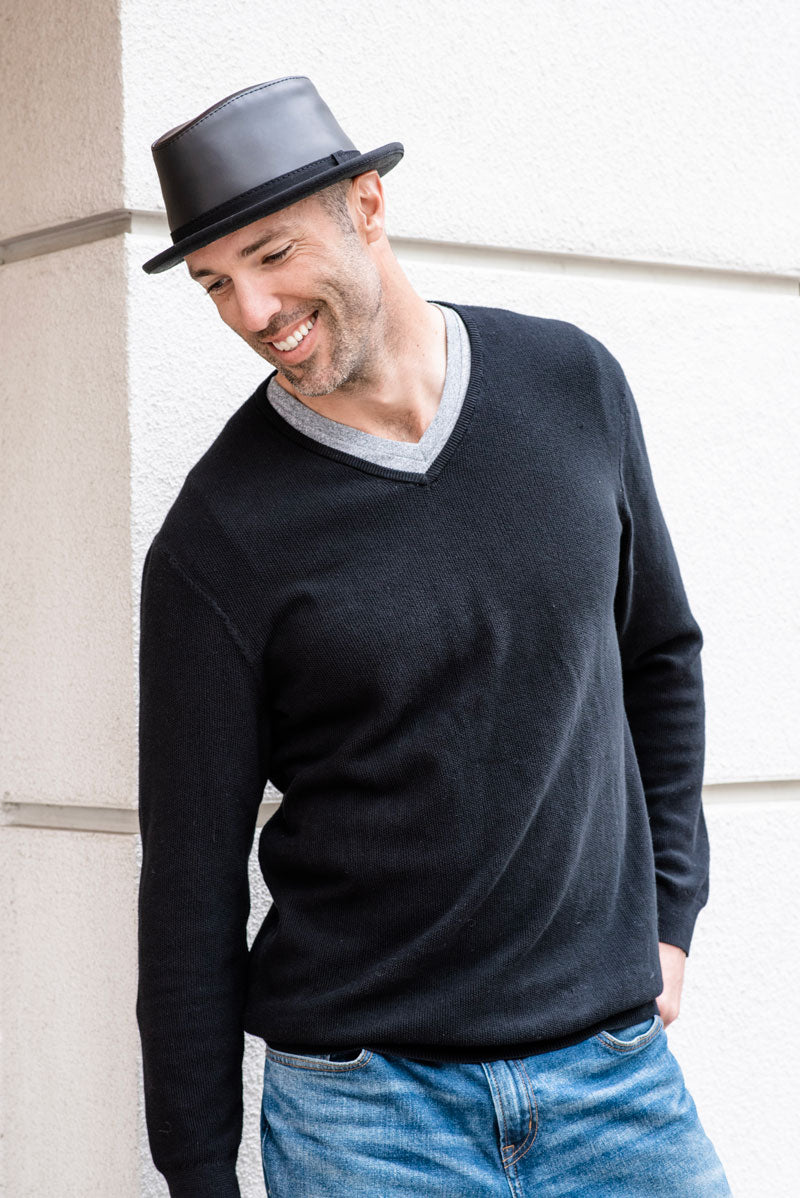 A man in a sweatshirt wearing Soho Black Leather hat