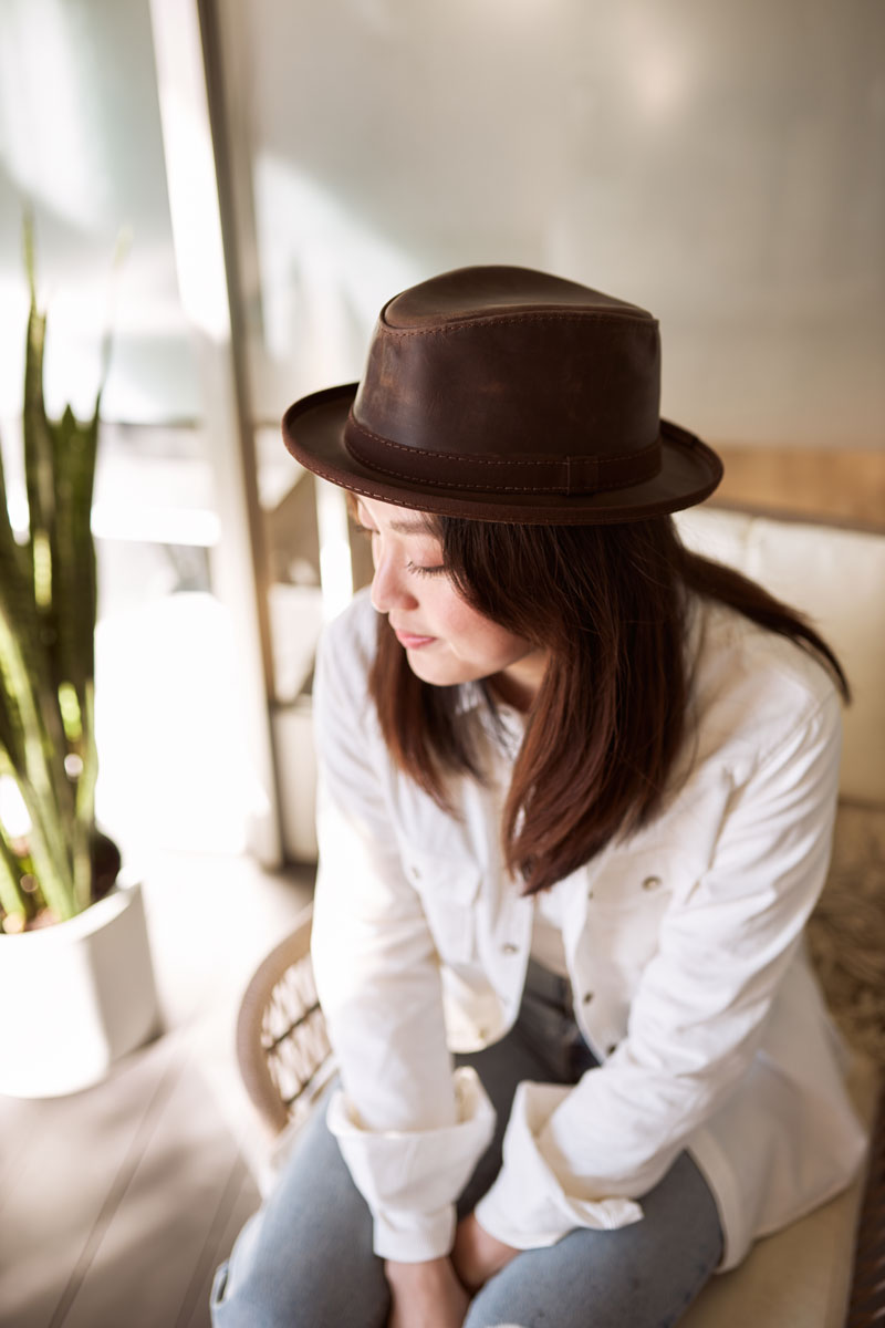 A woman wearing chocolate leather hat