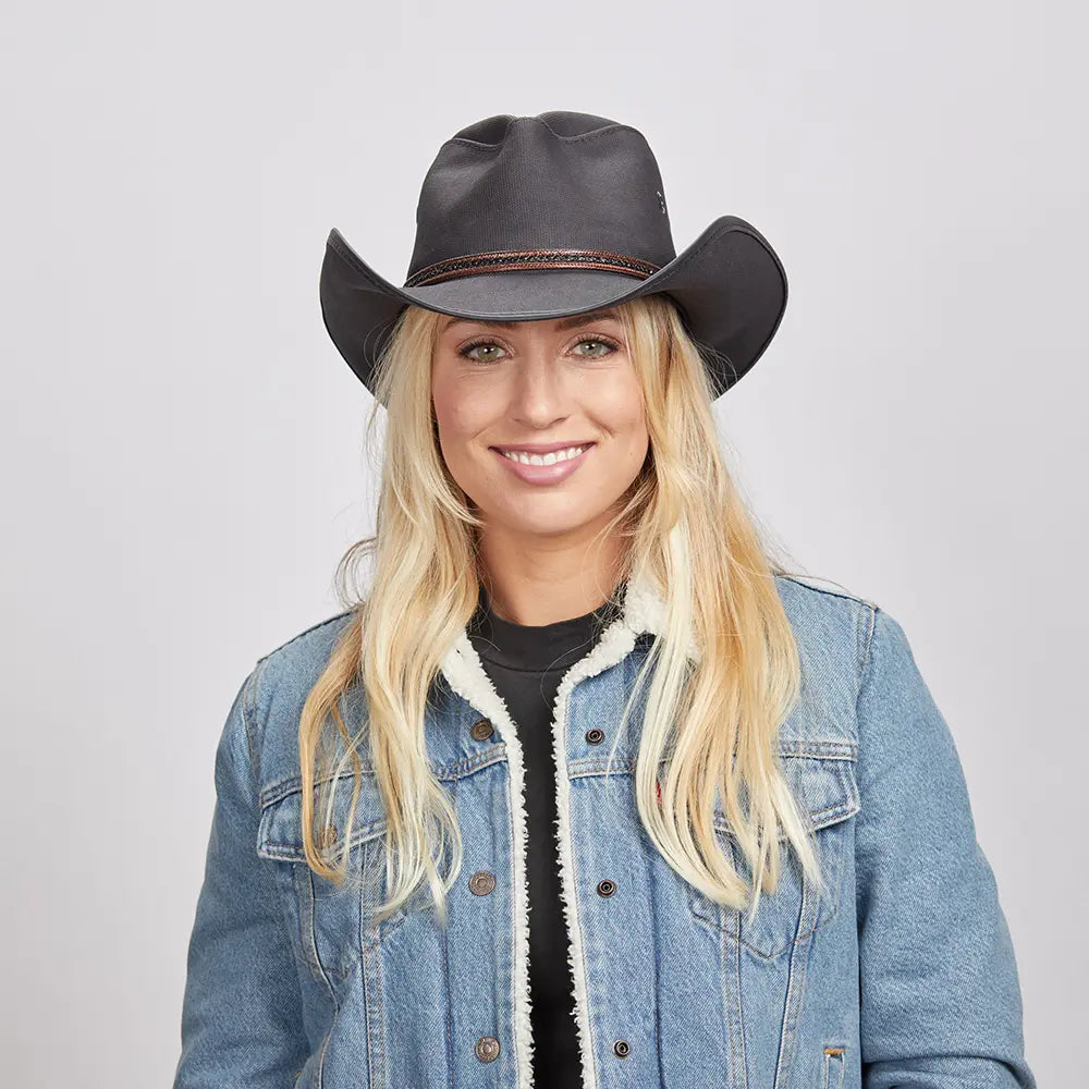 A blonde woman in denim jacket wearing the Black Stockade Vegan Cowboy Hat